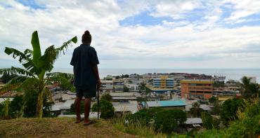 A gardener working on the grounds of Solomon Islands National Parliament takes in the view of the capital
